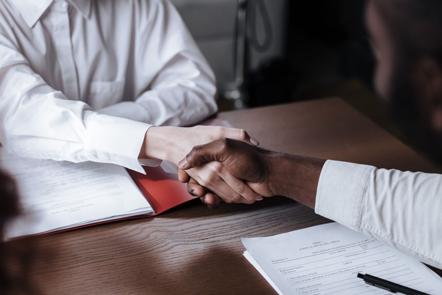 unrecognizable hands handshaking over table